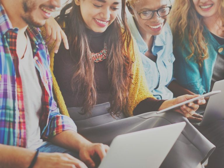 Groupe de jeunes souriants travaillant sur des ordinateurs portables et des tablettes. Groupe de jeunes souriants travaillant sur des ordinateurs portables et des tablettes.